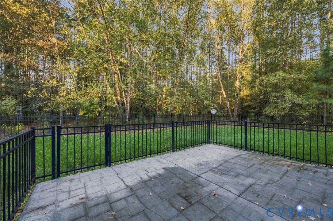 Paver patio featuring a fenced rear yard with mature trees