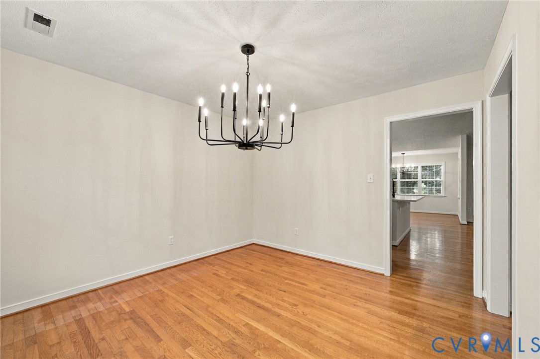 Wood-finish flooring and black metal multi-arm chandelier