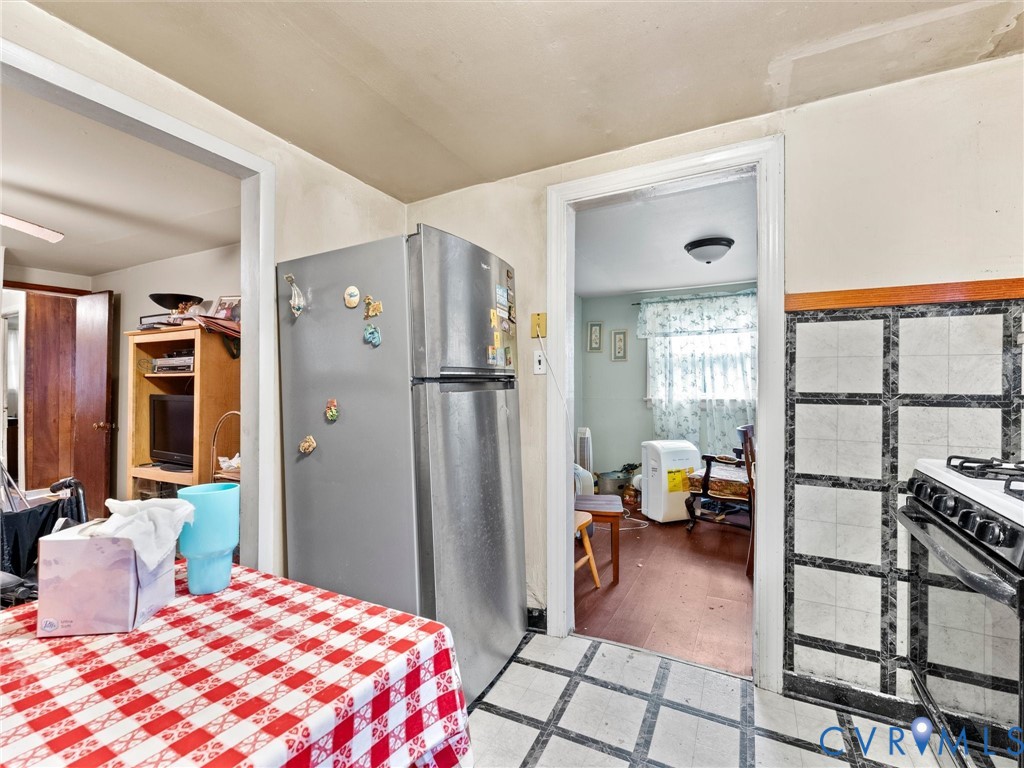 Kitchen featuring a stainless steel refrigerator and tiled backsplash with a grid pattern
