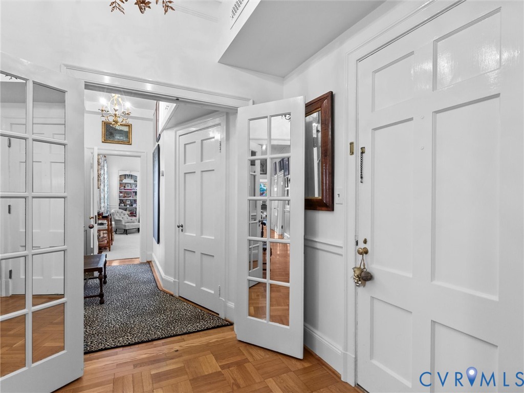 Private Primary entrance, Parquet wood-finish flooring, white paneled interior doors, and French-style glass-paneled doors with polished brass hardware Private Primary entrance, Parquet wood-finish flooring, white paneled interior doors, and French-style glass-paneled doors with polished brass hardware
