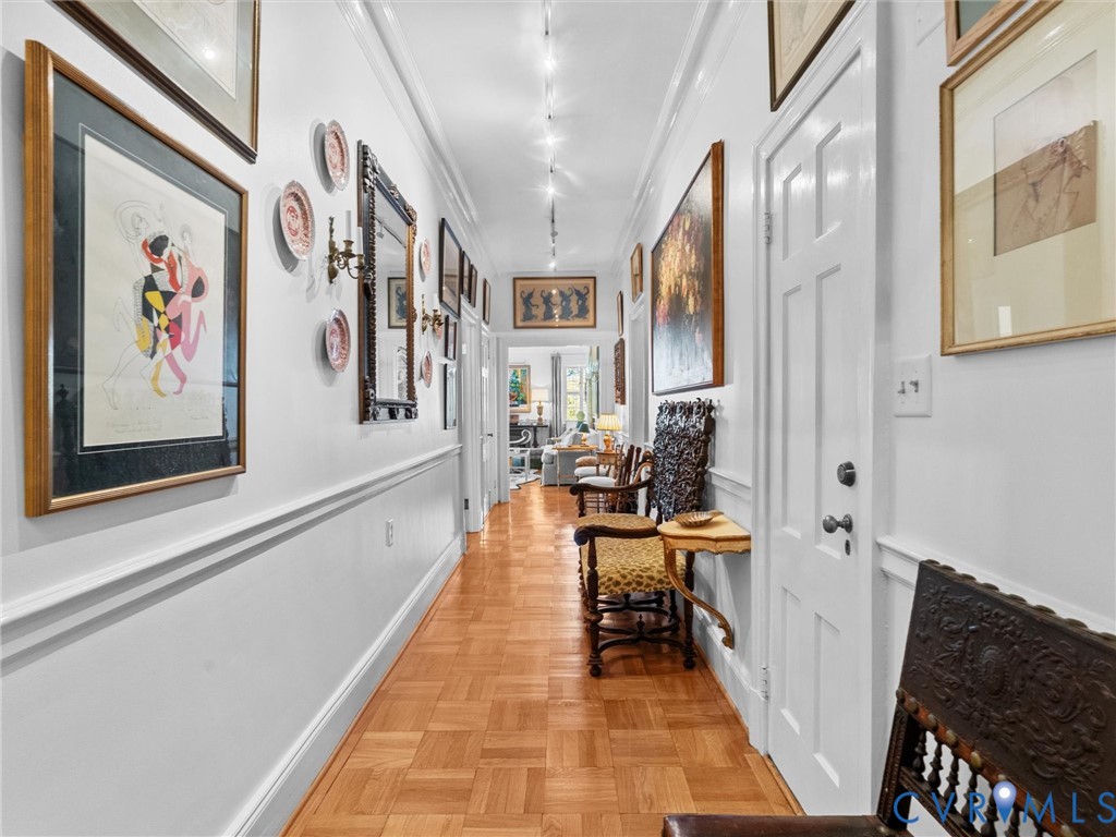 Hallway, Parquet wood-finish flooring, decorative chair rail molding, and recessed ceiling track lighting Hallway, Parquet wood-finish flooring, decorative chair rail molding, and recessed ceiling track lighting