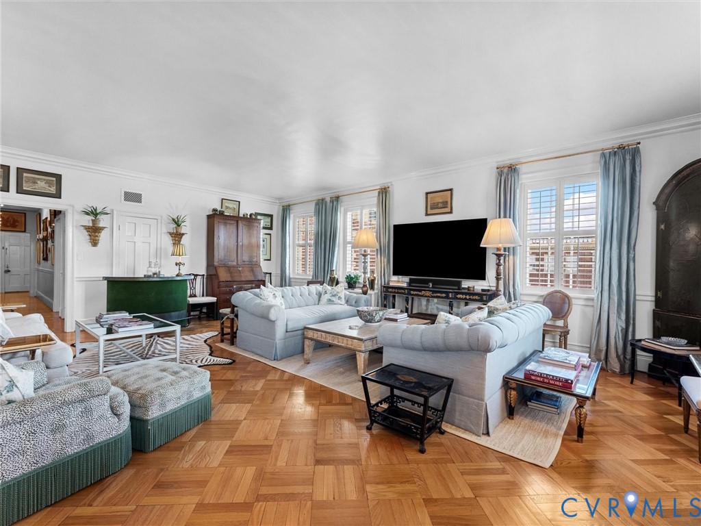 Parquet wood-finish flooring, plantation shutters, crown molding, and wainscoting