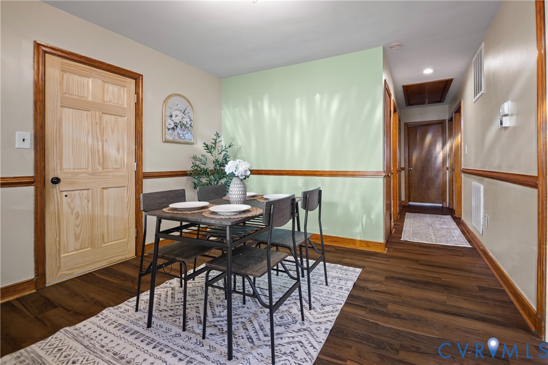 Interior space featuring wood-finish flooring, wood-panel doors, decorative chair rail molding, and a recessed ceiling lighting fixture