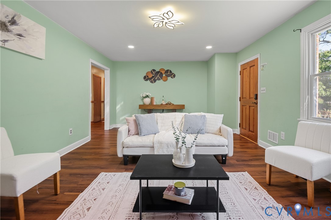Wood-finish flooring, decorative petal-style ceiling lighting, recessed lighting, and a six-panel wood door Wood-finish flooring, decorative petal-style ceiling lighting, recessed lighting, and a six-panel wood door