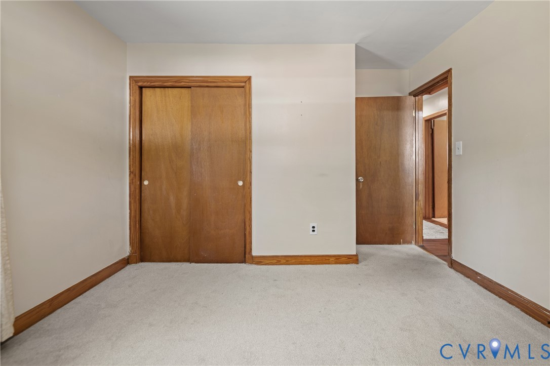 Neutral carpeting, wood-finish closet doors, and wood-finish door trim