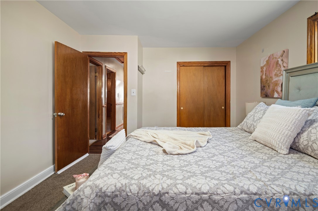 Room featuring neutral wall tones, wood-finished interior doors, and a double-door closet with wood trim