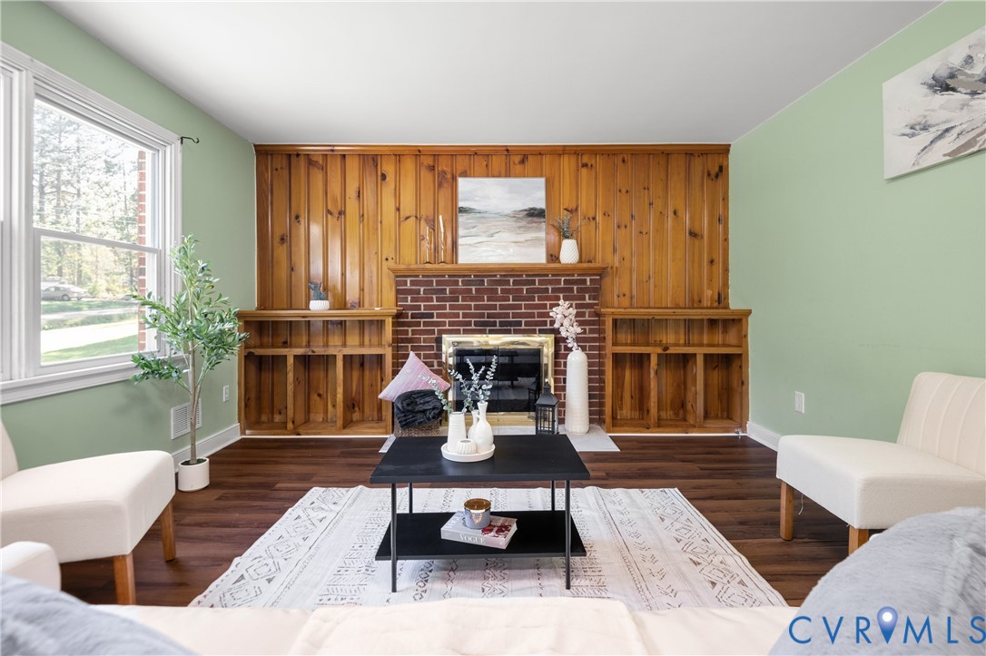 Brick fireplace with wood mantel, vertical wood paneling, and built-in shelving, complemented by wood-finish flooring Brick fireplace with wood mantel, vertical wood paneling, and built-in shelving, complemented by wood-finish flooring