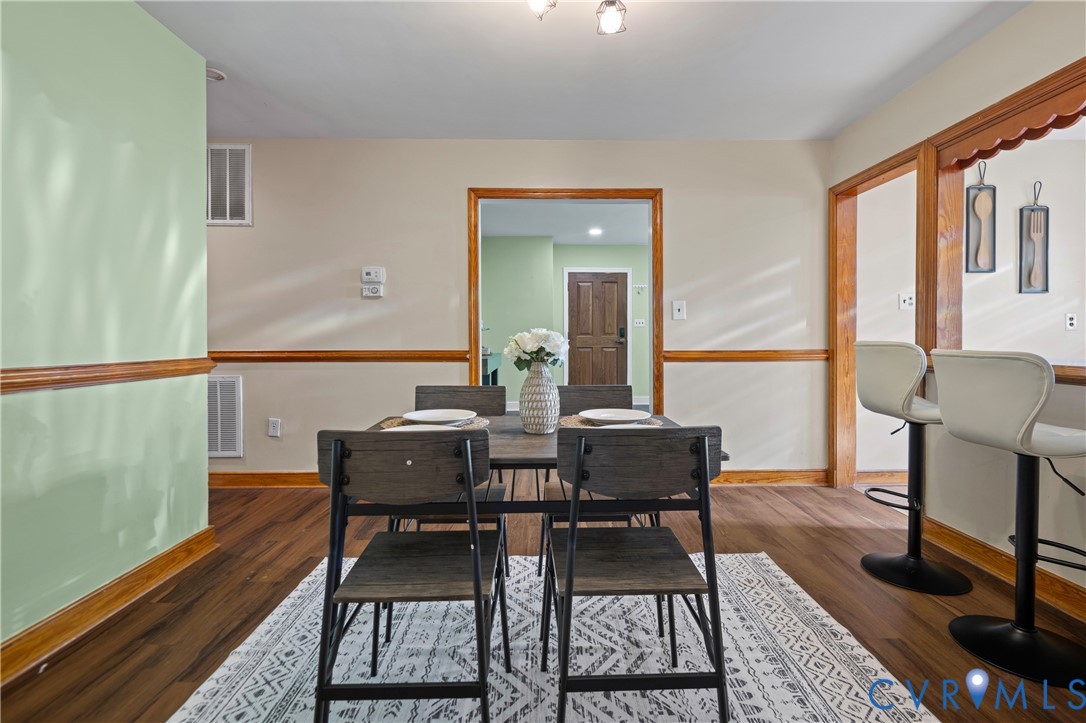 Wood-finish flooring, wood trim throughout, and a pass-through opening with wood casing