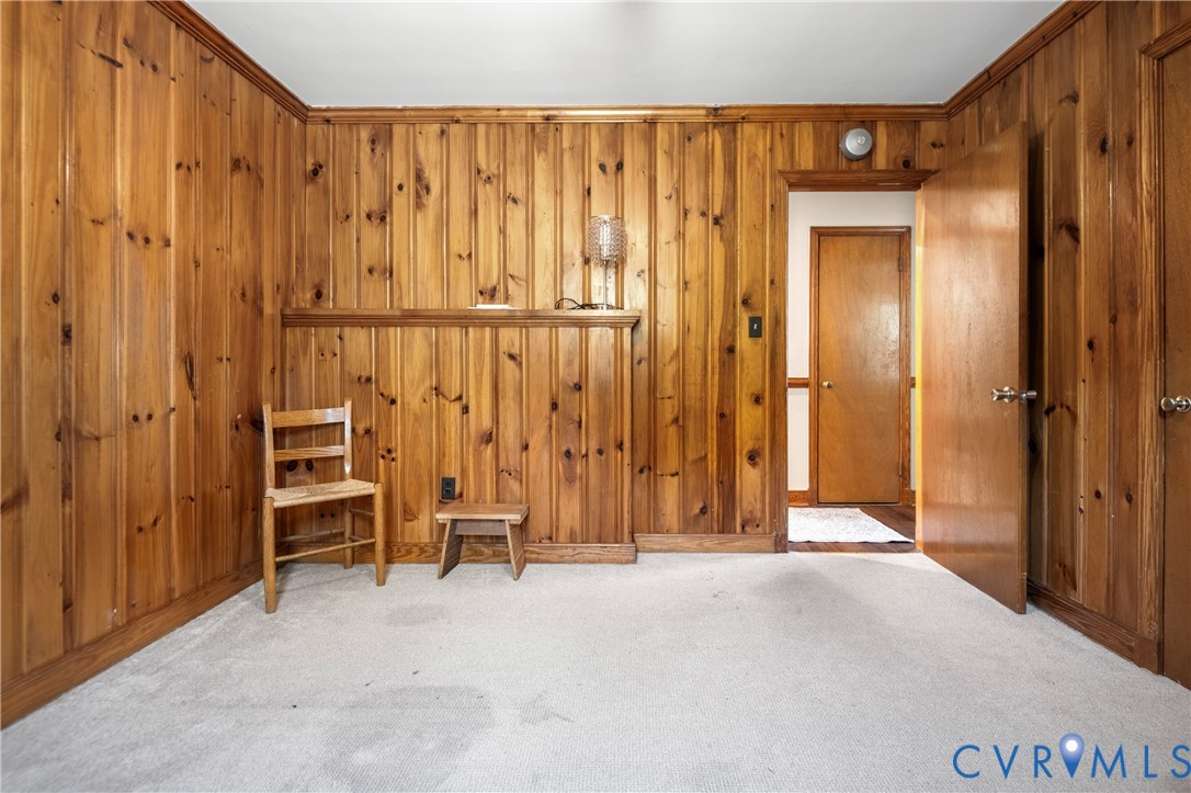 Interior space featuring floor-to-ceiling wood paneling, a built-in waist-high wood ledge, and an interior wood door