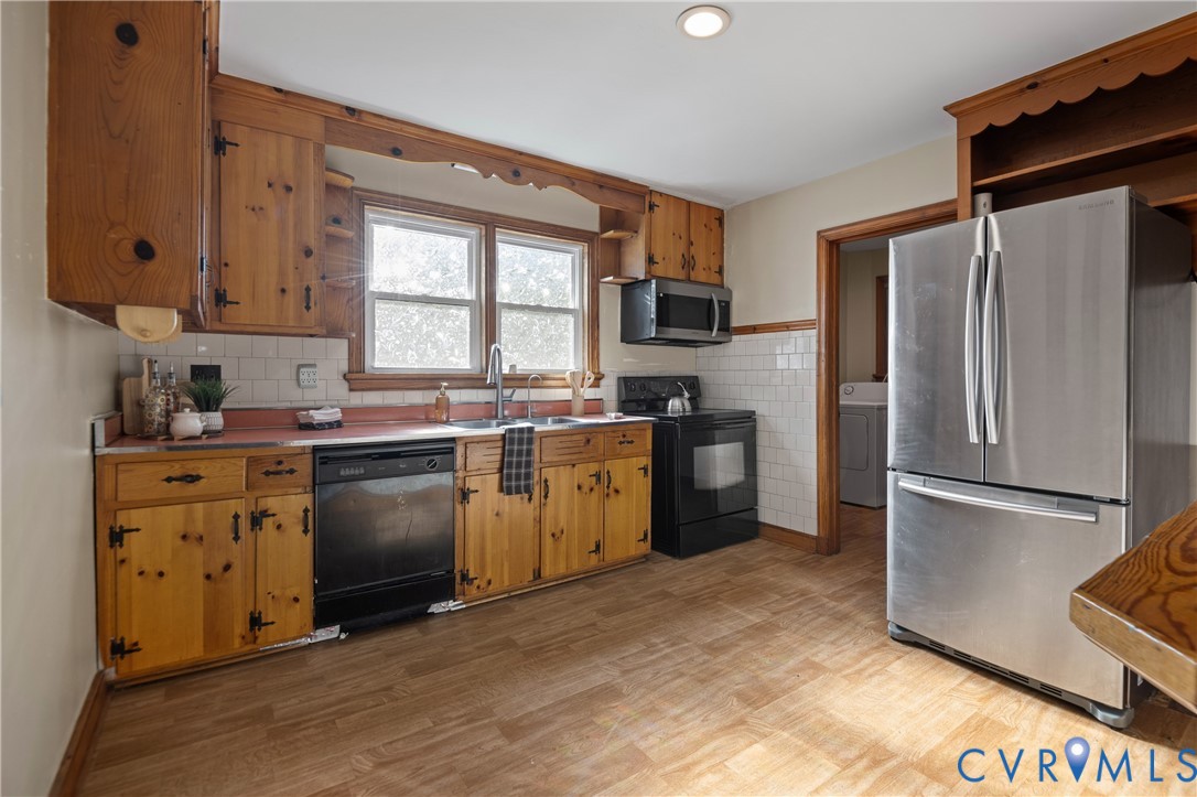 Kitchen featuring knotty pine cabinetry, white subway tile backsplash, stainless steel French-door refrigerator, and wood-finish flooring