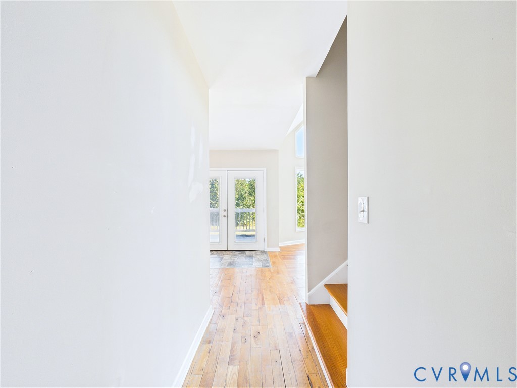Hallway from front door leading to grand room space