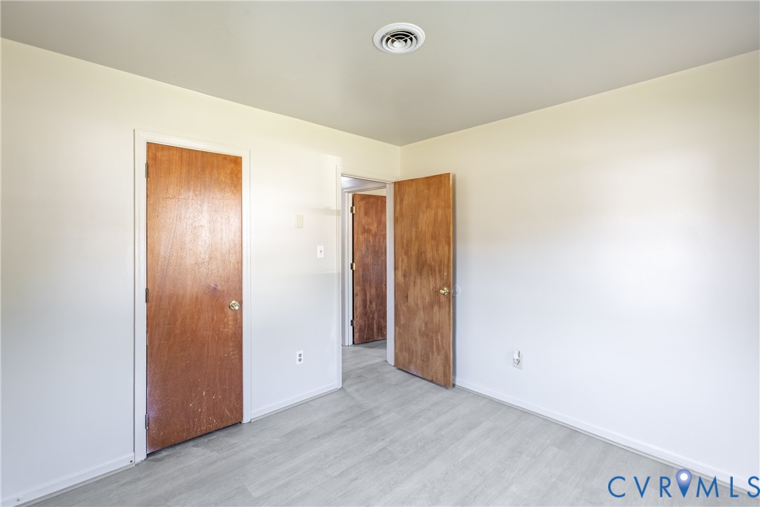 Neutral wall finishes, wood-finish interior doors with metallic hardware, and light-toned wood-finish flooring