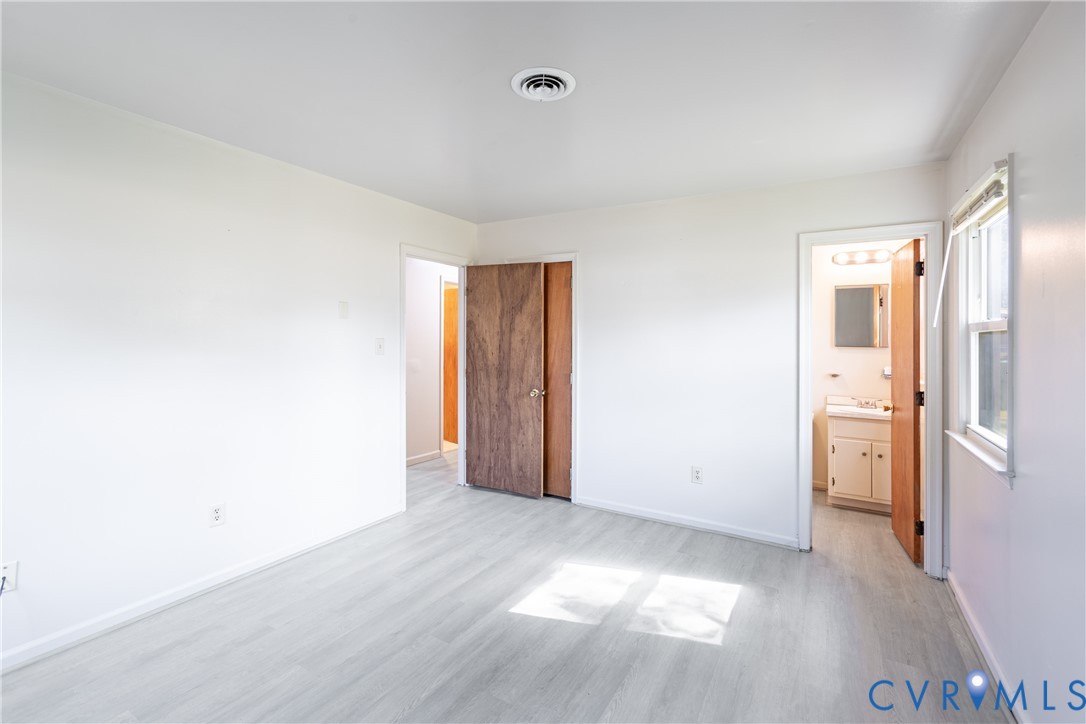 Neutral-toned wood-finish flooring, white walls, and interior wood-grain doors