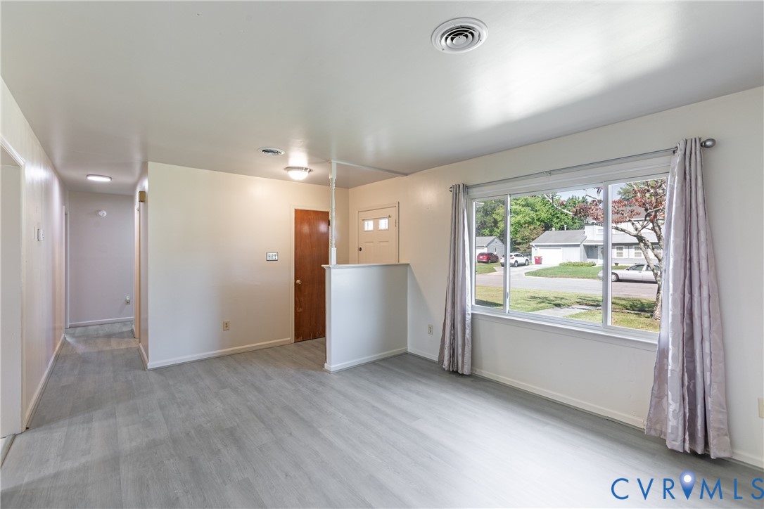 Interior featuring wood-finish flooring, a large picture window, and a built-in partial room divider