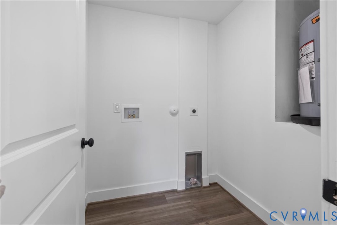 Utility area featuring wood-finish flooring, white walls, and dedicated laundry connections
