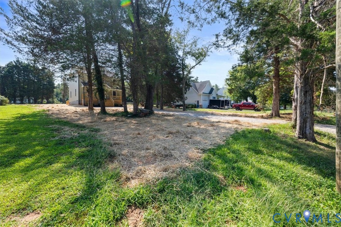 Expansive lot featuring mature trees, cleared grounds, and residential structures