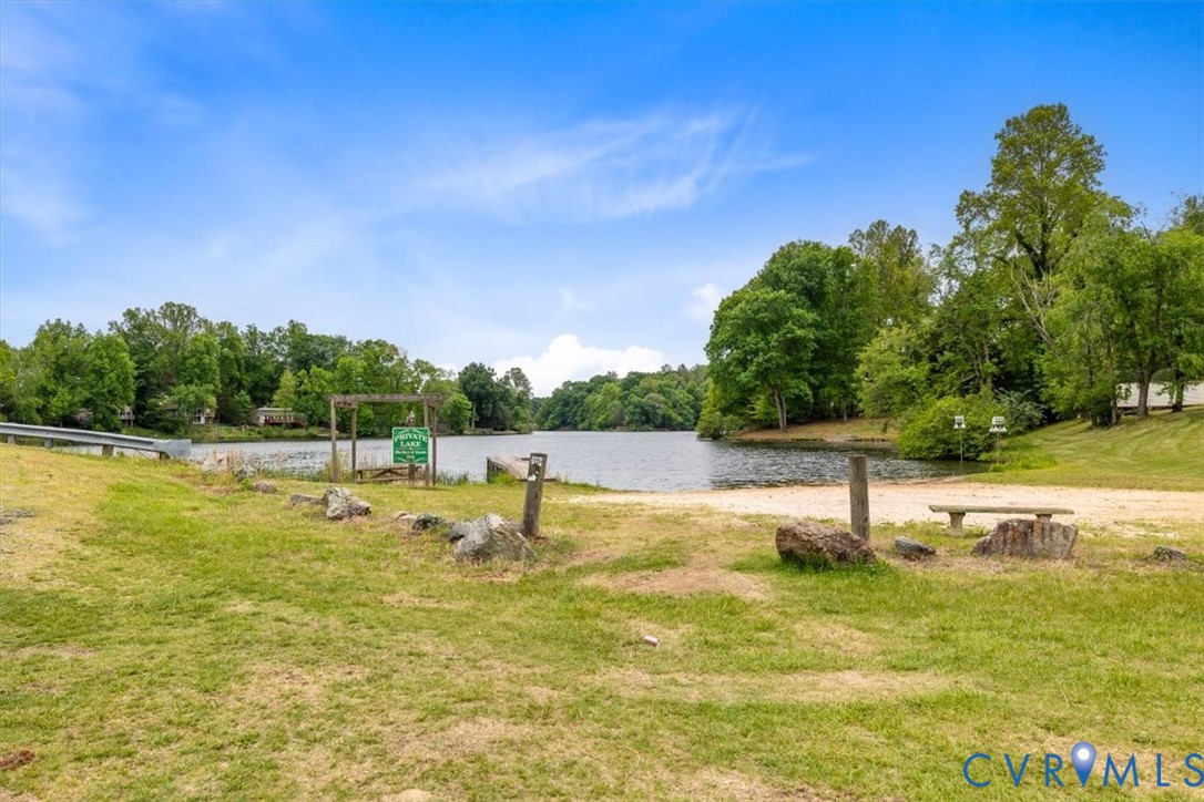 Waterfront grounds featuring a natural shoreline, mature trees, and grass-covered terrain
