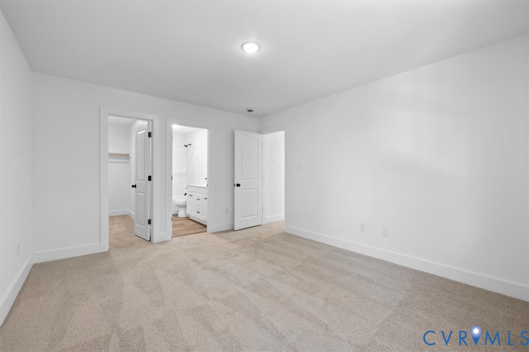 Neutral carpeting, recessed ceiling lighting, three-panel interior doors, and a reach-in closet featuring built-in shelving
