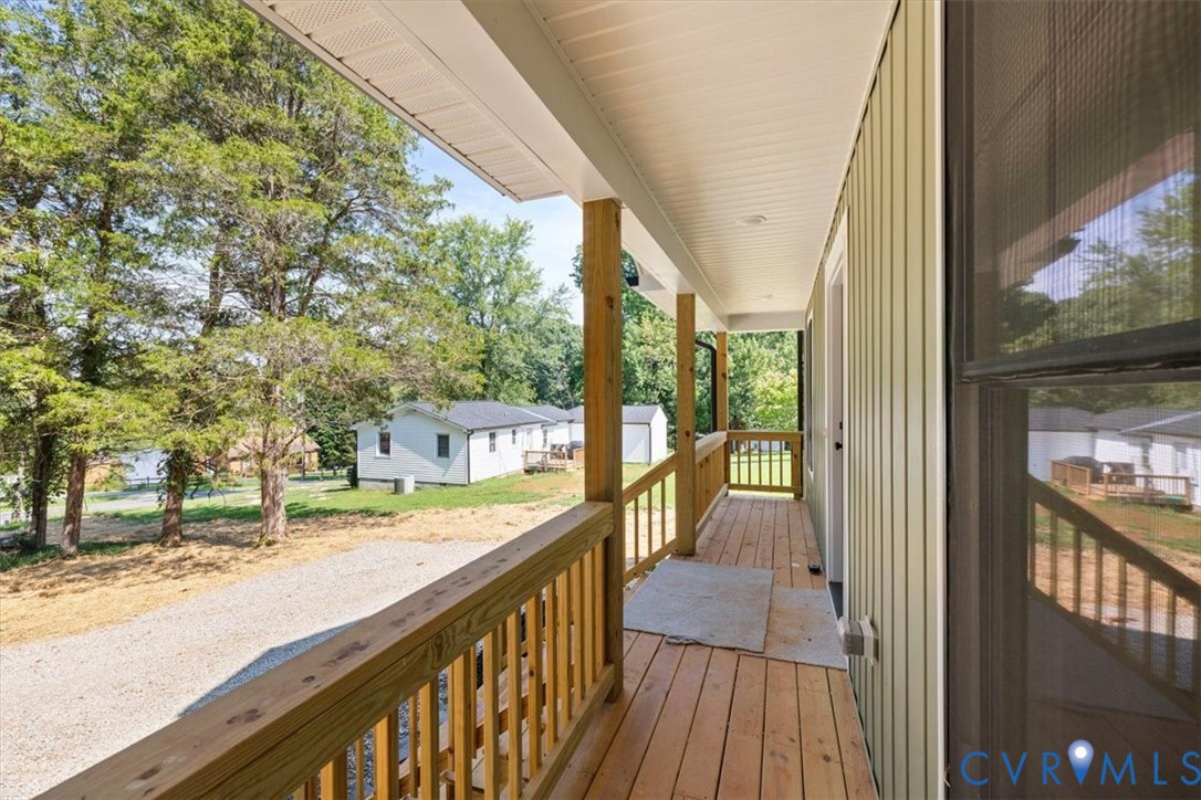 Covered porch featuring wood decking, wood railing, vertical siding, and recessed ceiling lighting
