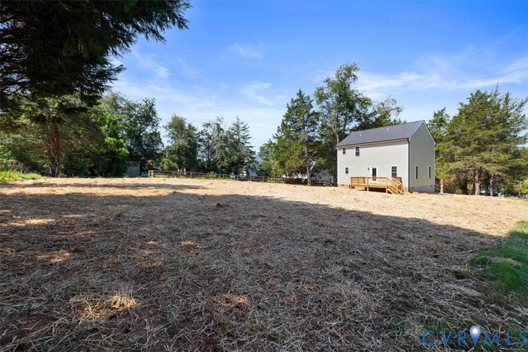 Expansive lot featuring mature perimeter trees and a wood deck