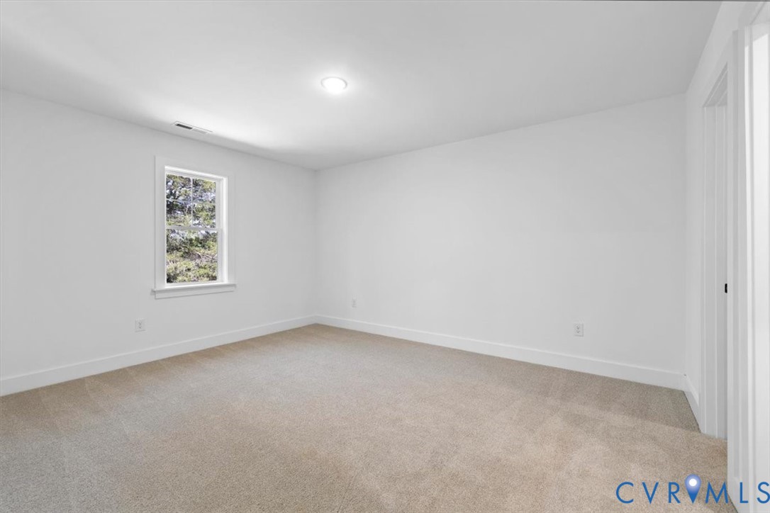 Neutral-toned carpeting, crisp white walls, and a single-hung window