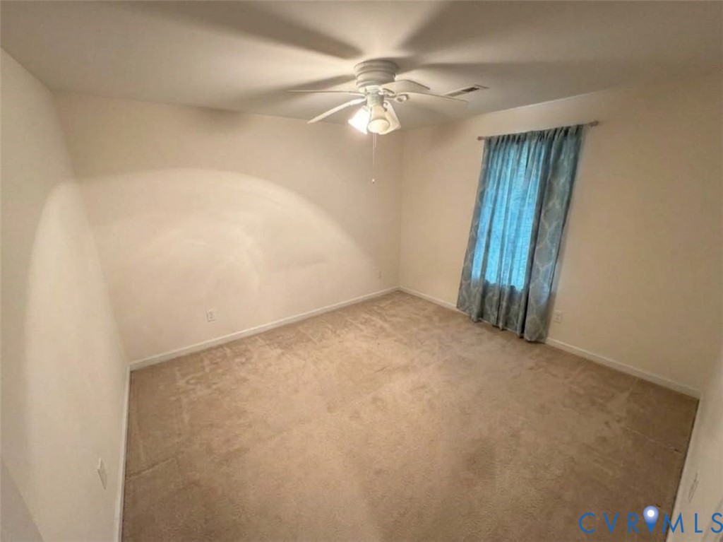 Neutral-toned carpeting, white walls, and a ceiling-mounted light fixture with a fan