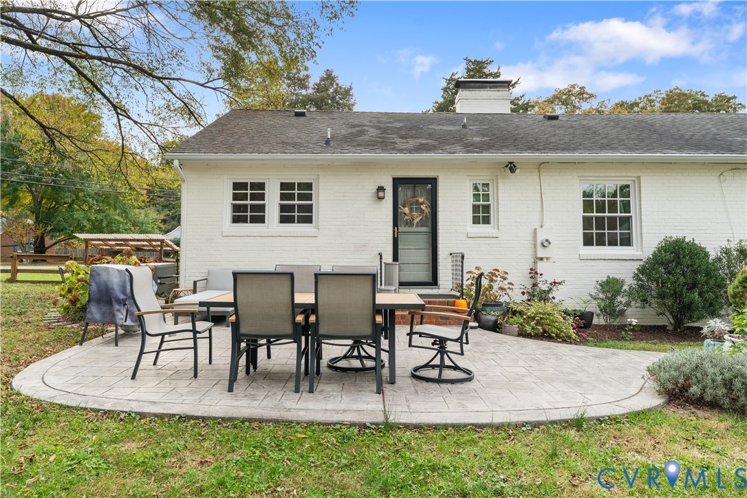 Painted brick exterior, stamped concrete patio, chimney, and multi-pane windows