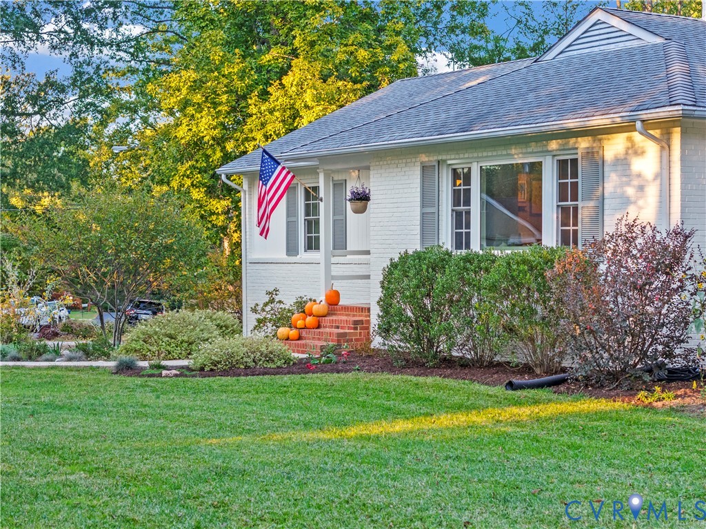 White-painted brick exterior featuring a shingled roof, multi-pane windows, decorative shutters, and red brick front steps White-painted brick exterior featuring a shingled roof, multi-pane windows, decorative shutters, and red brick front steps