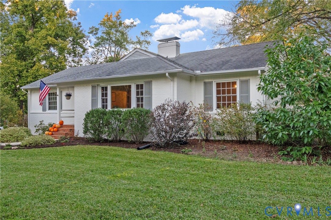 Painted brick exterior featuring a multi-gabled roofline, central chimney, divided-light windows with shutters, and masonry front steps Painted brick exterior featuring a multi-gabled roofline, central chimney, divided-light windows with shutters, and masonry front steps
