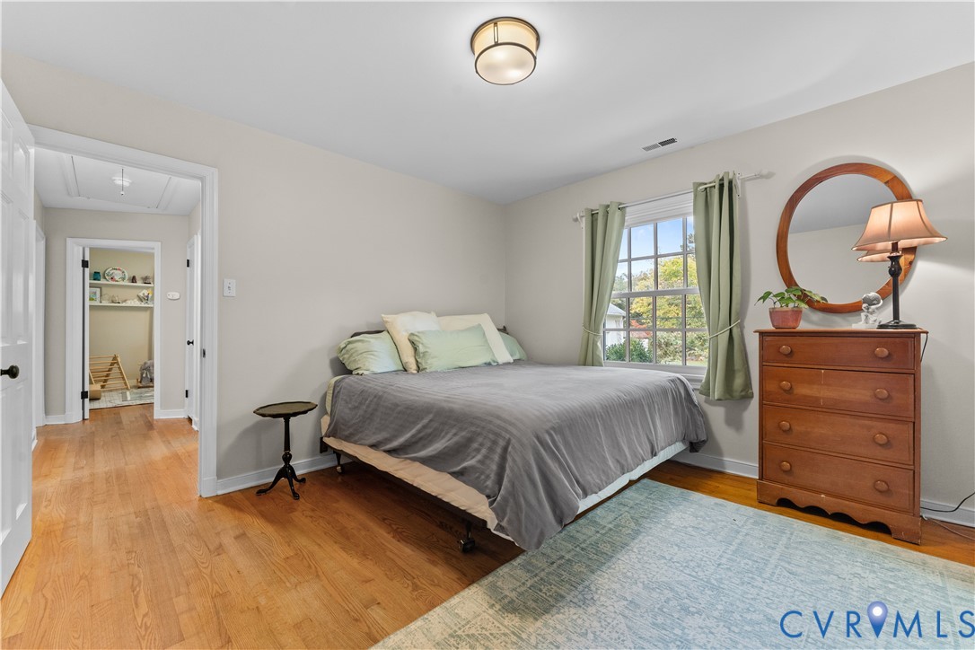 Hardwood flooring, multi-pane window with natural light, and flush-mount ceiling lighting