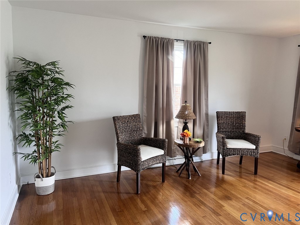 Bright room featuring wood-finish flooring and neutral-toned wall paint