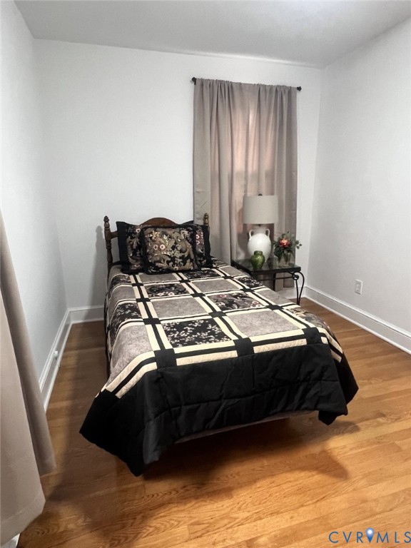 Room featuring wood-finish flooring and neutral-toned wall paint