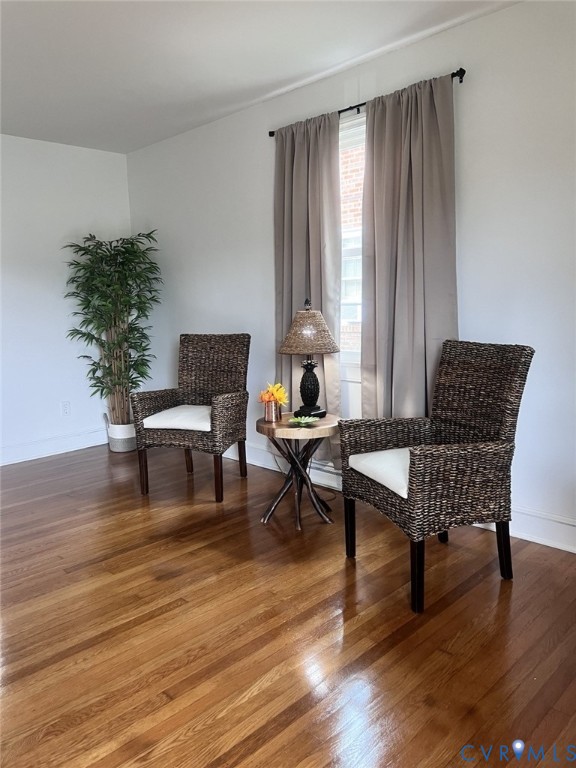 Wood-finish flooring and a single-hung window featuring a curtain rod