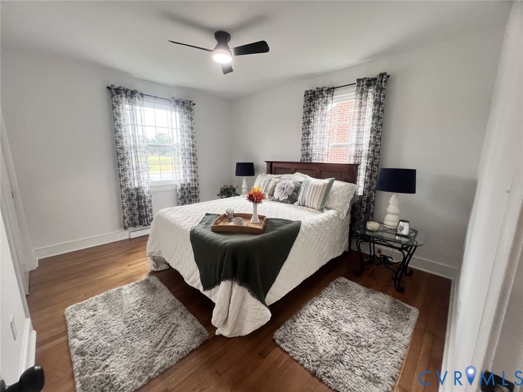 Hardwood flooring, multi-pane windows, and a ceiling fan with integrated lighting
