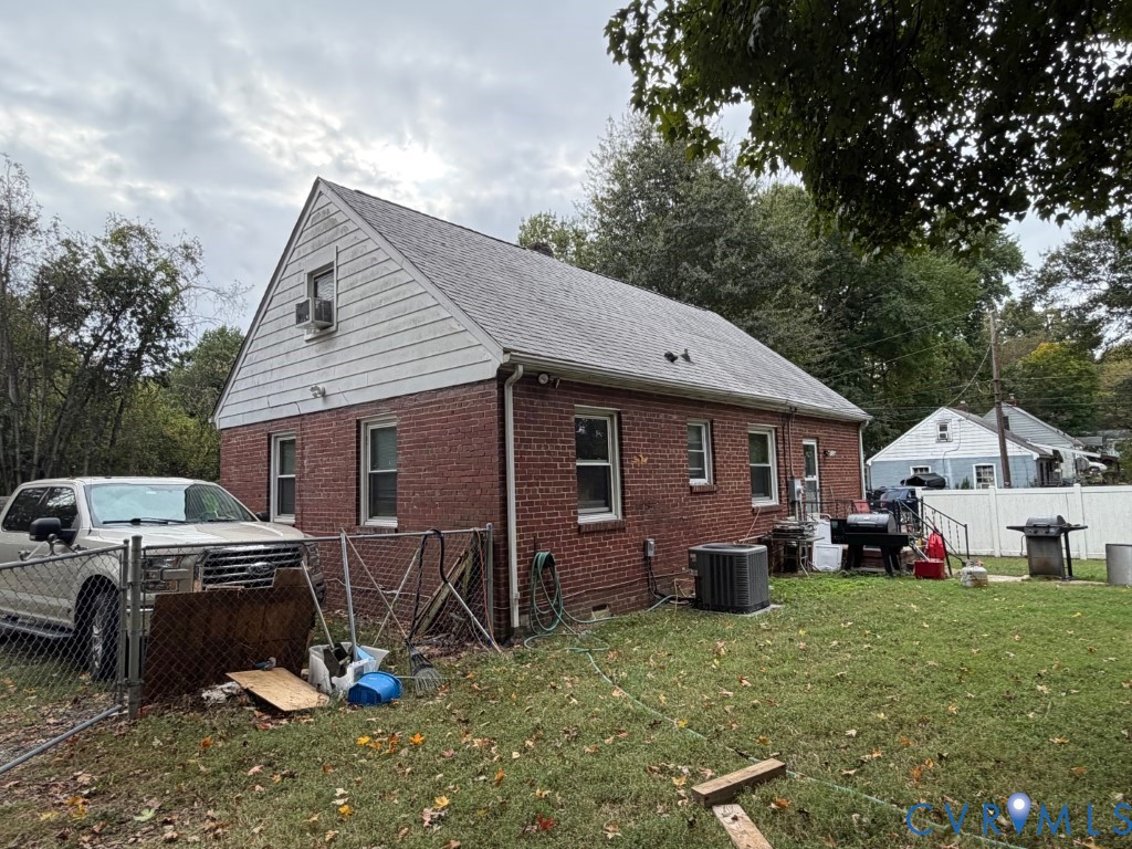 Brick exterior featuring gable roofline, white horizontal siding on the upper level, and a fenced yard
