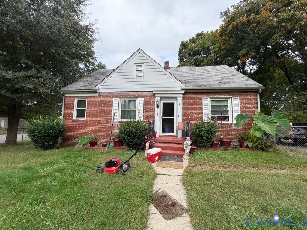Traditional brick exterior featuring a gable roof, white-trimmed windows with shutters, and a concrete walkway Traditional brick exterior featuring a gable roof, white-trimmed windows with shutters, and a concrete walkway
