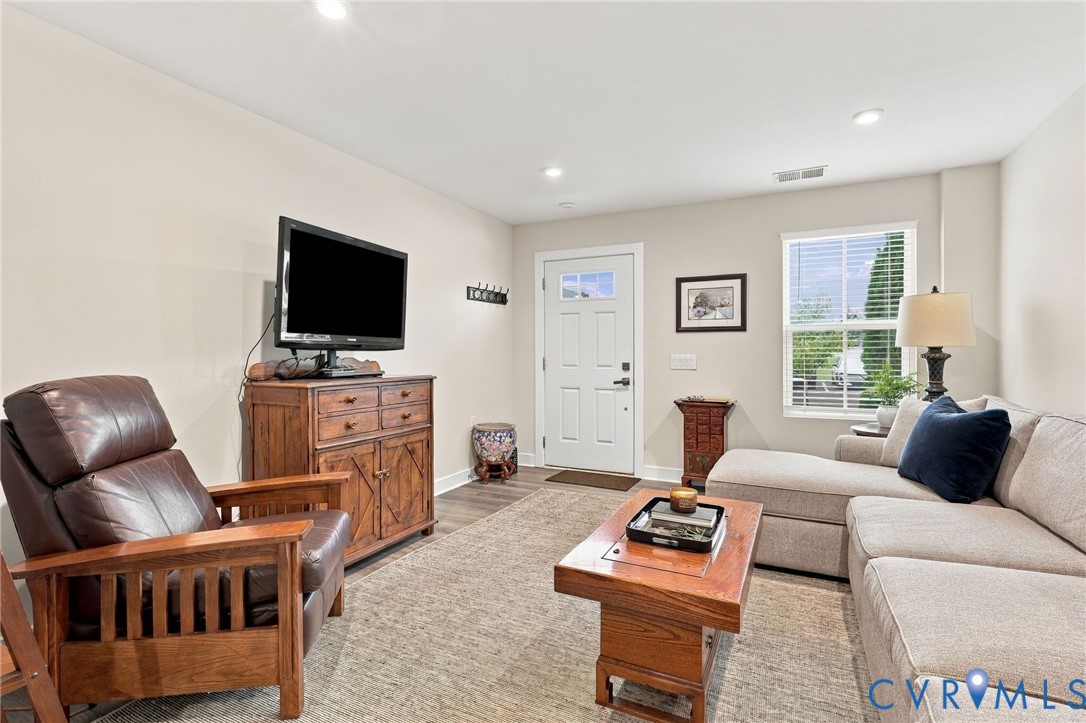 Interior space featuring wood-finish flooring, recessed lighting, and a paneled entry door with an integrated window pane
