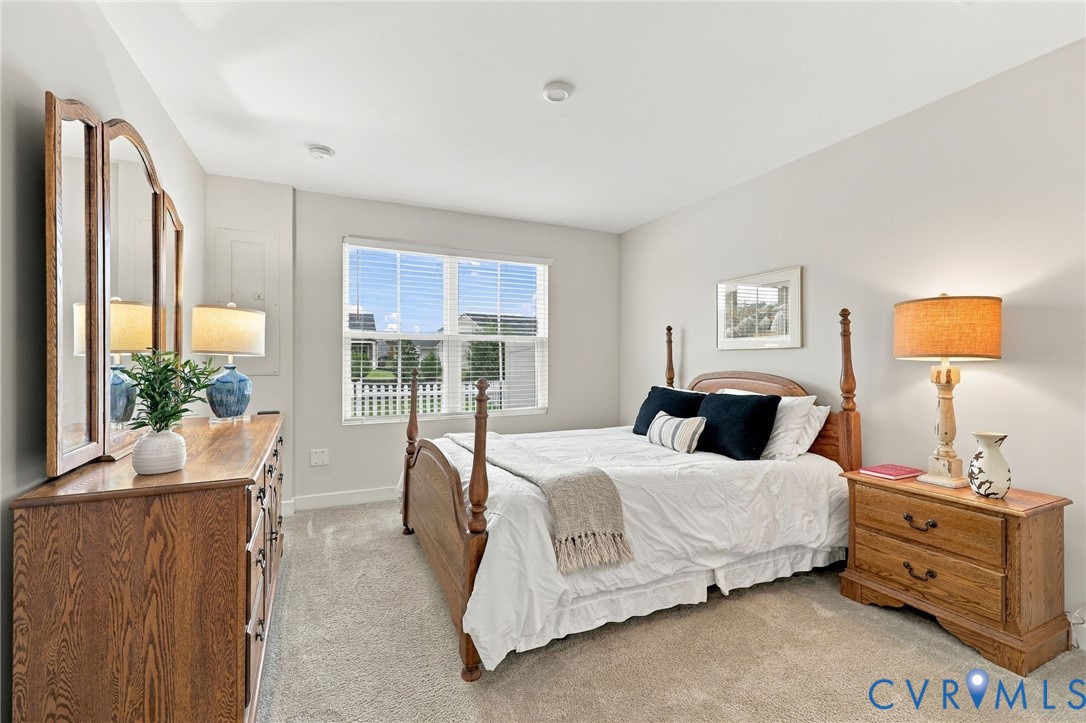 Neutral wall coloring, carpeted flooring, and a window with horizontal blinds