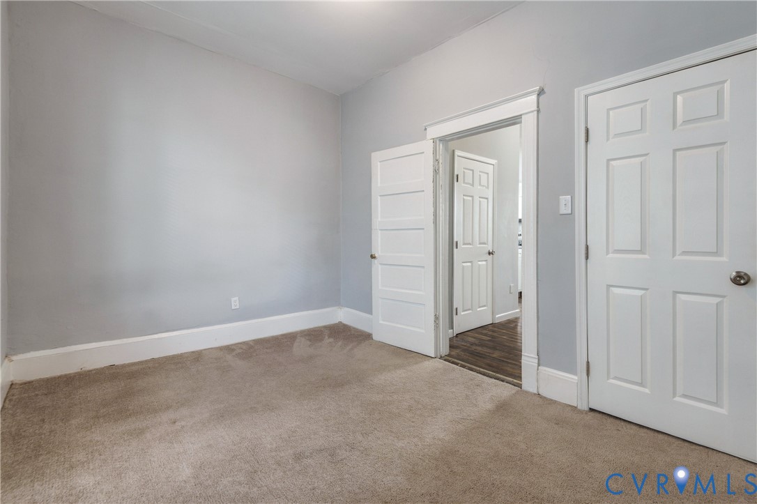 Interior space featuring neutral-toned carpeting, crisp white interior door trim, and paneled doors