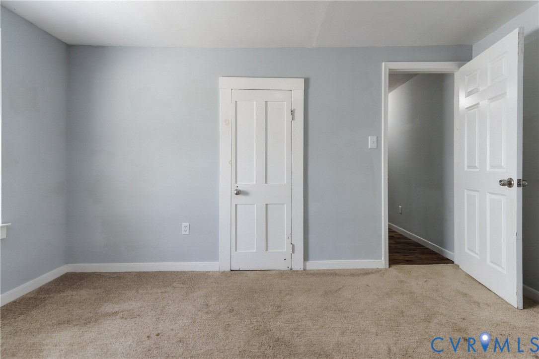 Neutral-toned wall paint, four-panel interior doors, and carpeting