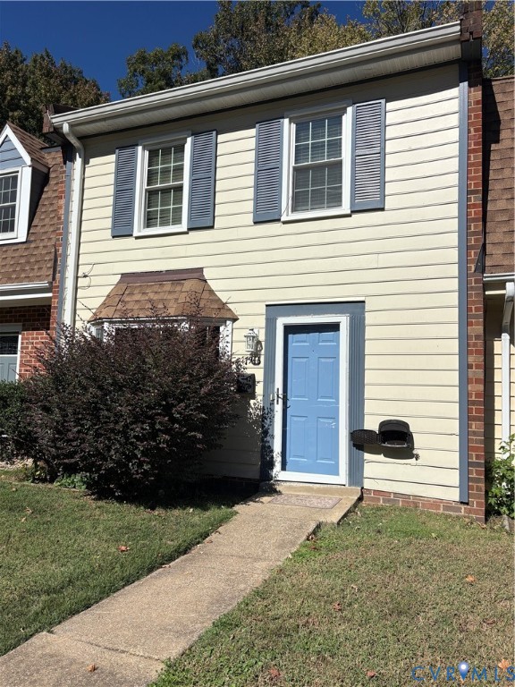 Two-story exterior featuring horizontal siding, dark-trimmed shutters, a bay window with shingled roofing, and a concrete walkway Two-story exterior featuring horizontal siding, dark-trimmed shutters, a bay window with shingled roofing, and a concrete walkway