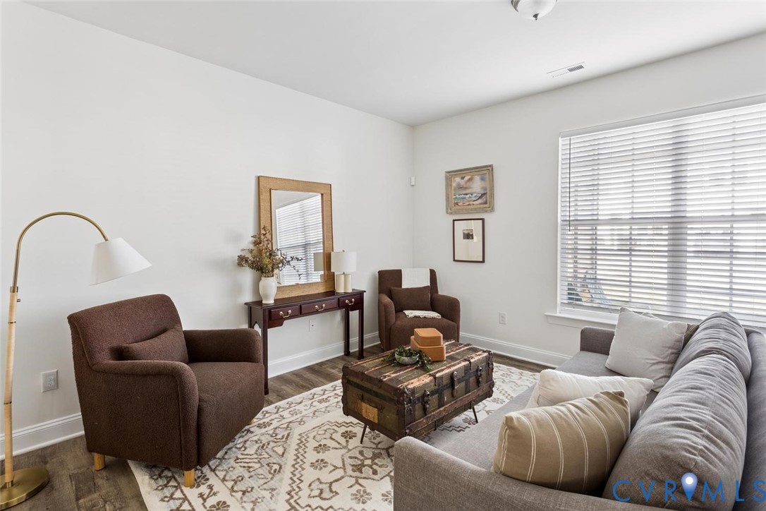 Recessed lighting, LVP flooring, white walls, and a large windows with blinds.