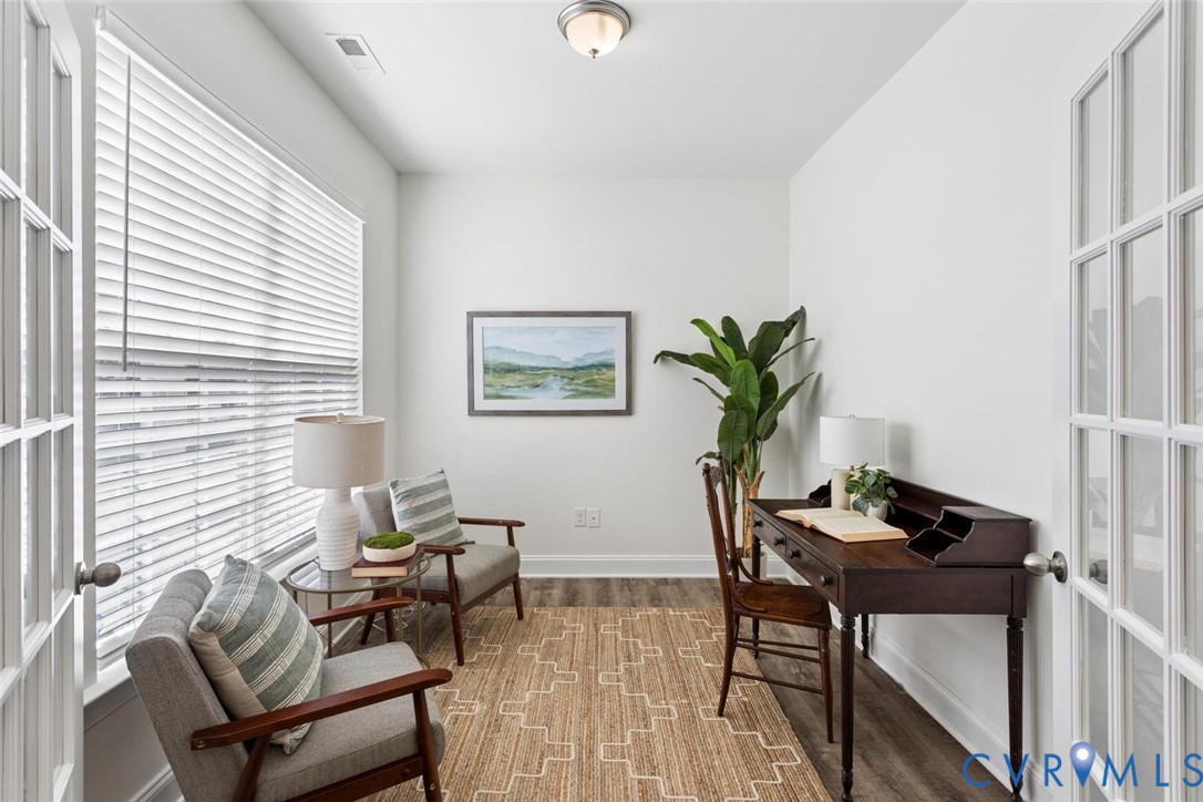 French doors with glass paneling, LVP flooring, white walls, large window with blinds, and a flush mount light fixture.