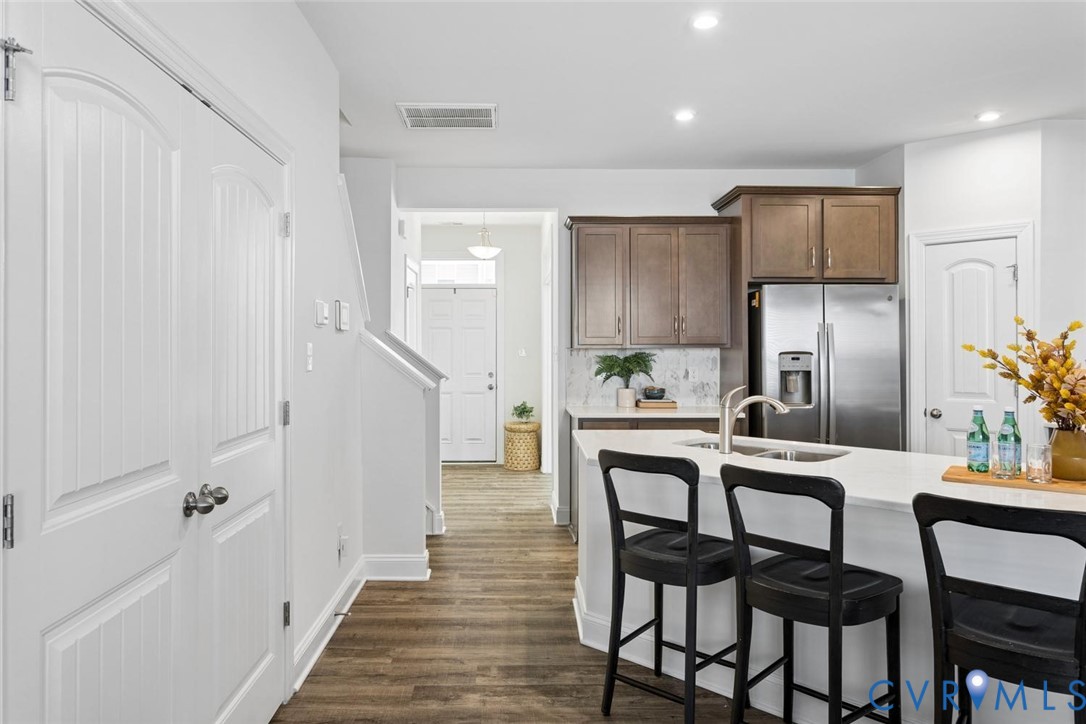 Kitchen with wood-finish flooring, white countertops, and stainless steel appliances.
