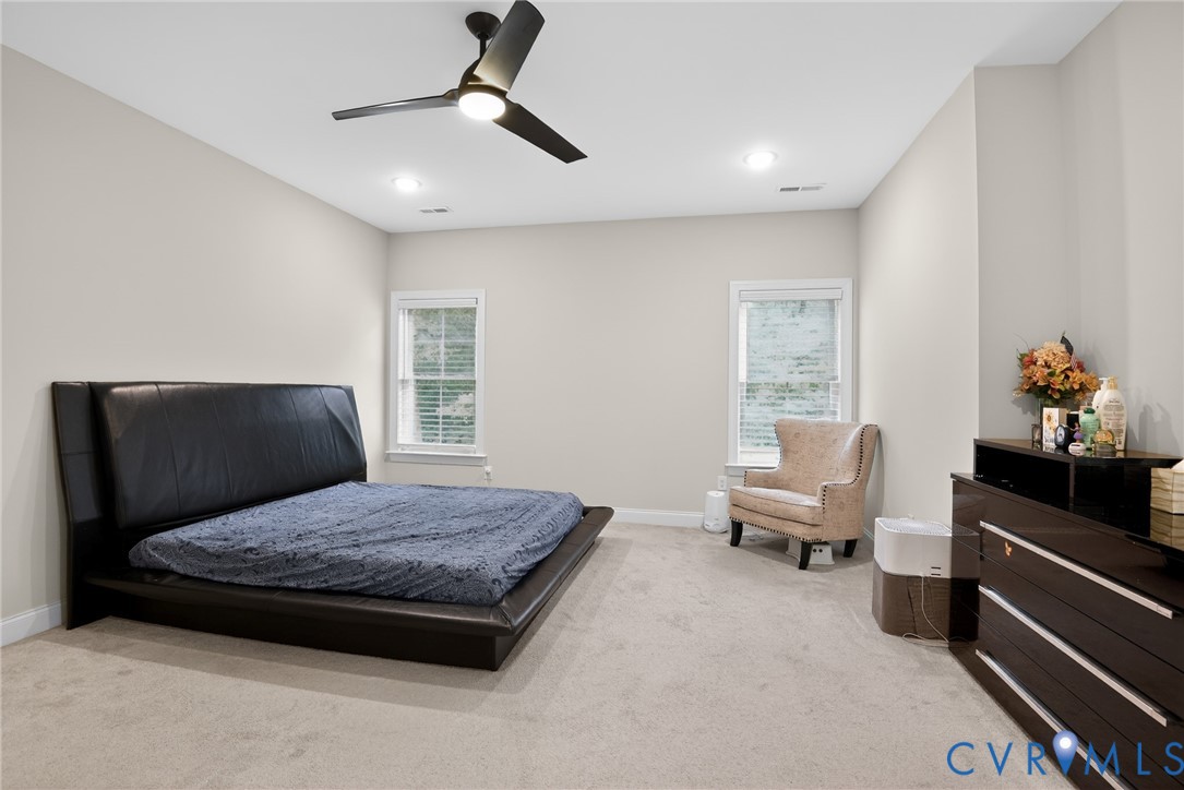 Neutral-toned interior featuring wall-to-wall carpeting, recessed lighting, and a modern ceiling fan with integrated light