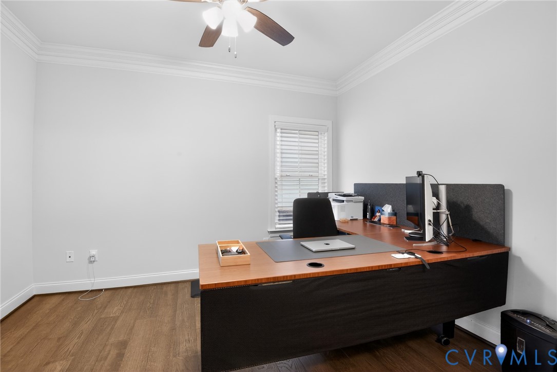 Room featuring wood-finish flooring, crown molding, and a ceiling fan with integrated lighting