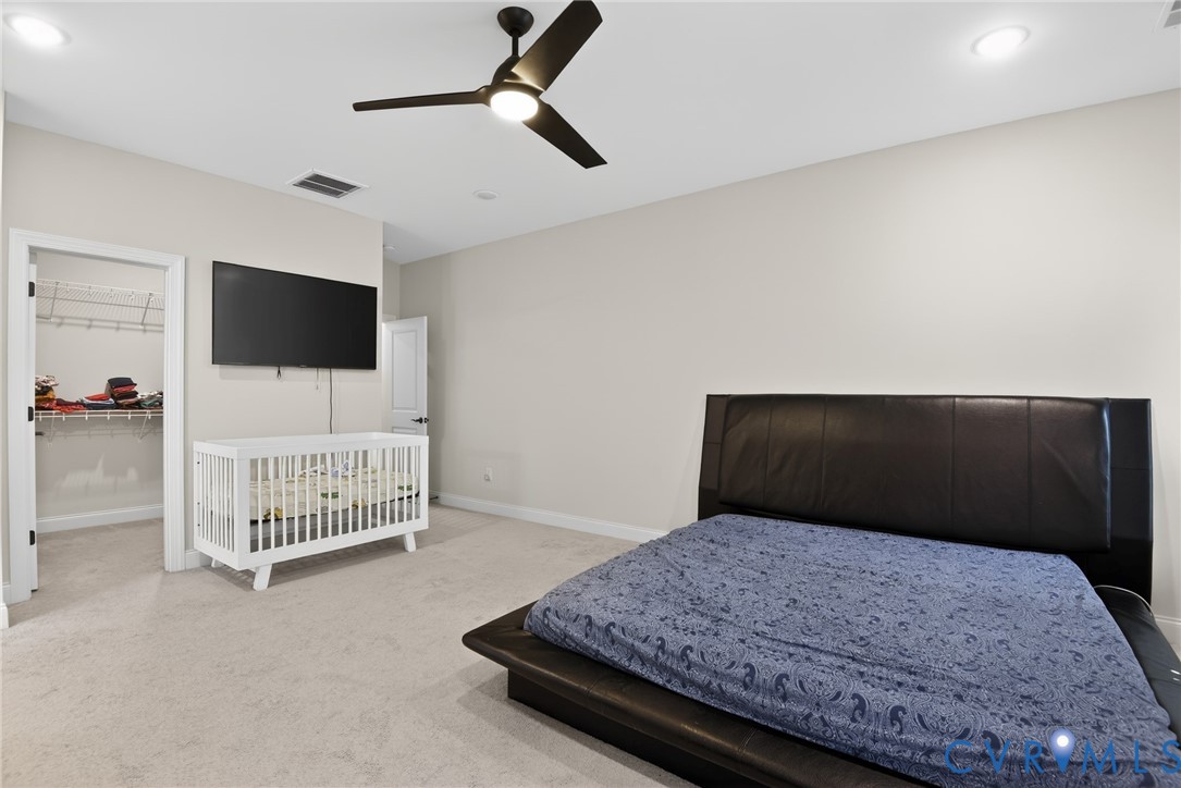 Neutral-toned interior featuring recessed lighting, a multi-blade ceiling fan with integrated lighting, and carpeted flooring