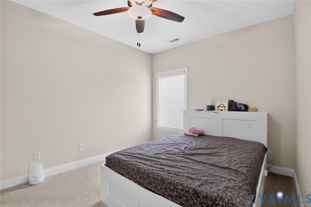 Room featuring neutral wall paint, carpeted flooring, and a ceiling fan with integrated lighting
