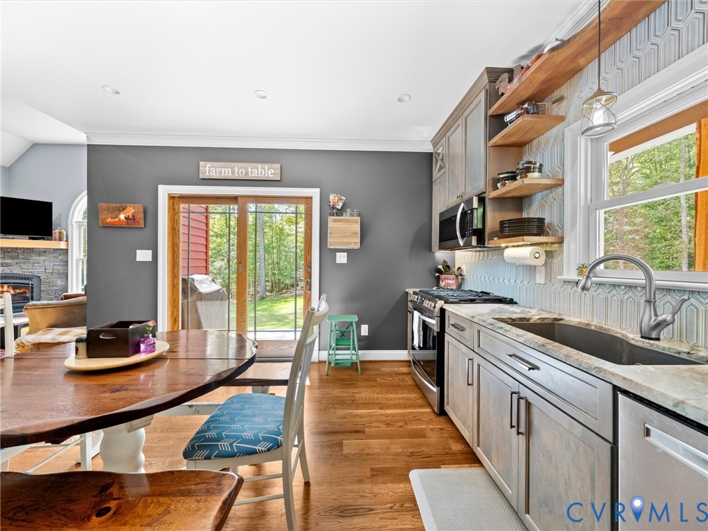 The custom kitchen offers beautiful granite countertops, stainless steel appliances, a stylish tile backsplash, and abundant cabinetry. Sliding glass doors provide direct access to the covered porch, perfect for outdoor dining and enjoying the peaceful country views!