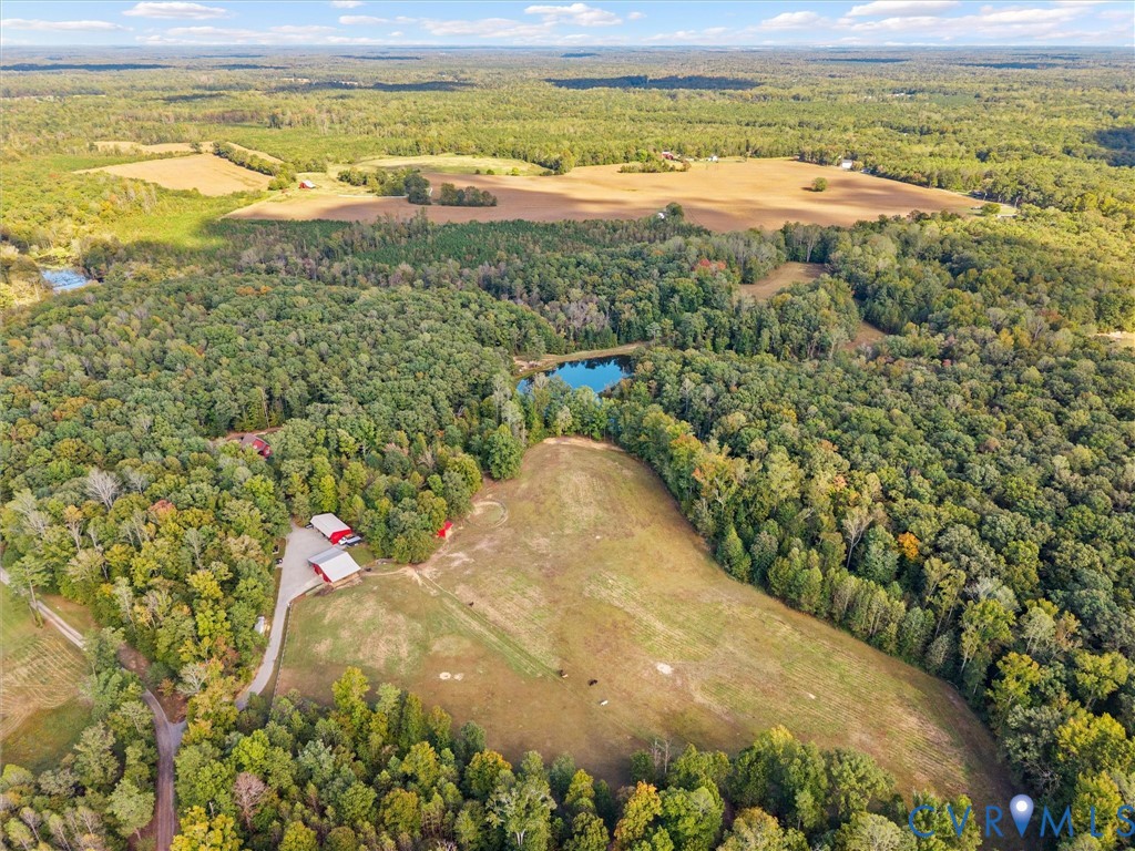 A breathtaking aerial view showcases the natural beauty and privacy of The Little Red Homestead! Spanning approximately 26.7 acres, this exceptional property offers a picturesque blend of rolling pastures, mature woodlands, scenic riding trails, and a beautiful stocked pond. A rare opportunity to enjoy the space, serenity, and endless possibilities of country living!